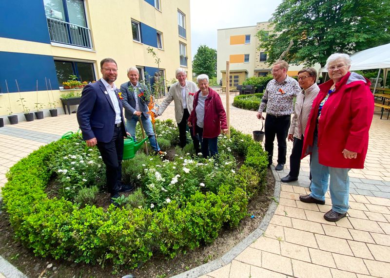 OB Thomas Nitzsche und AWO-Chef Frank Albrecht pflanzen mit Bewohnern einen Mirabellenbaum.