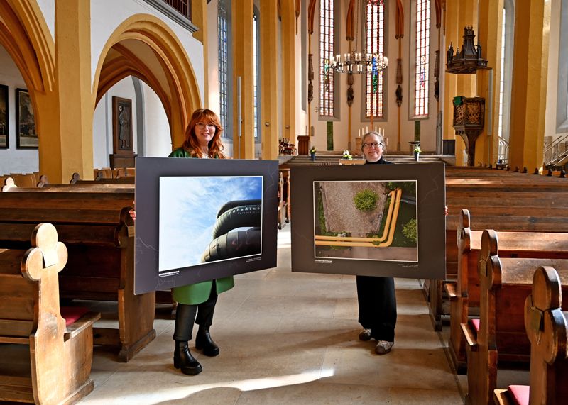 Ulrike Heyde von den Stadtwerken Energie (links) und Anya Schwammberger vom Team Stadtentwicklung geben mit zwei Bildern der Ausstellung „Best of Adern von Jena“ einen Vorgeschmack auf überraschende Perspektiven auf die Wärmeadern der Stadt.